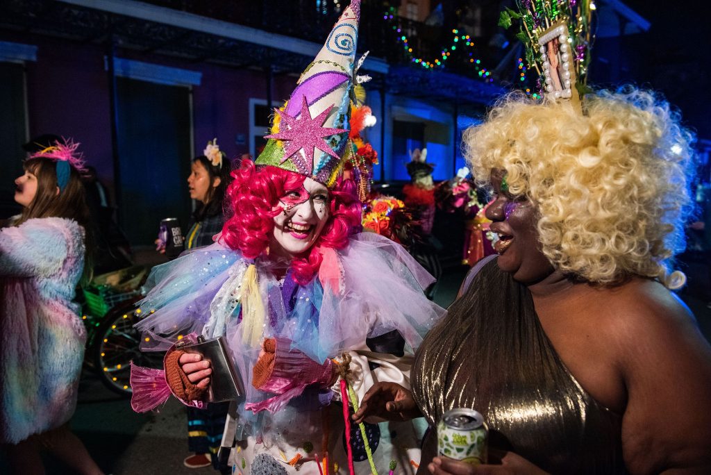 Krewe of Goddesses members share a revelrous laugh on the parade route.